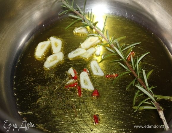 Положить 1 веточку розмарина, 1 зубчик чеснока, нарезанный тонкими кольцами, 1 измельченный пеперончино (чили), 1 щепотку сушеного тимьяна. Поставить на медленный огонь, нагреть до пузырьков так, чтобы масло приняло аромат специй.