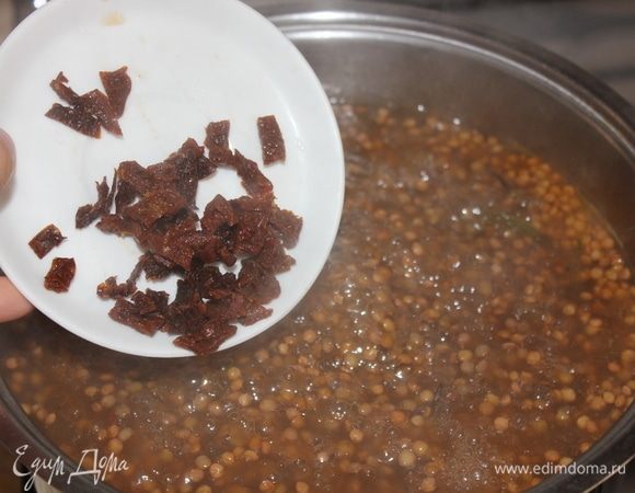 Примерно в середине варки, за 20 минут до готовности, всыпать 4 нарезанных сушеных помидора. Снова накрыть крышкой, убавить огонь до среднего и продолжать варить до готовности.