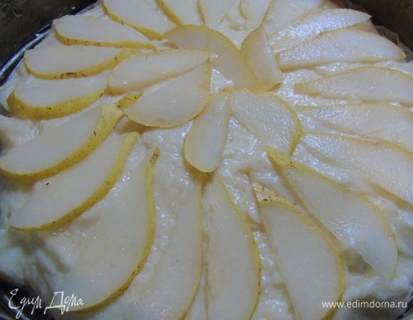 Дно формы 24 см выстелите пергаментом и смажьте маслом. Выложите тесто. Оставшиеся груши нарежьте дольками и выложите сверху.