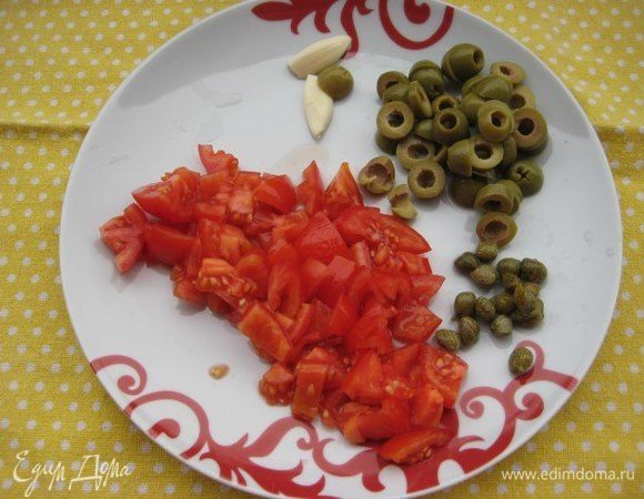 Помидоры (у меня 4 небольших сорта Сливка) нарезать мелко, каперсы промыть под проточной водой, нарезать колечками оливки, очистить зубчик чеснока, разрезать его вдоль.