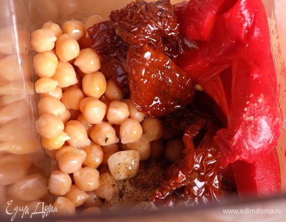 В чашу блендера поместить нут, вяленые томаты, перец, влить масло, добавить все специи, чеснок, лимонный сок и соль.