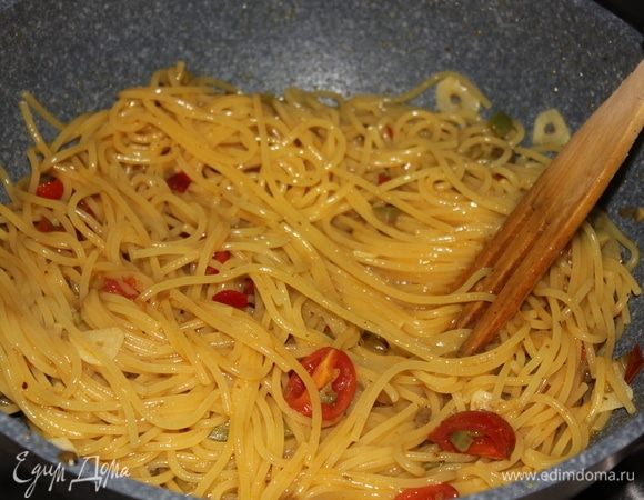 Примерно в течение 1,5 минут аккуратно, постоянно помешивая спагетти в сковороде, окончите готовить их. Если спагетти кажутся сухими, или выкипела вся жидкость, смело добавляйте немного воды, в которой варилась паста (спагетти).