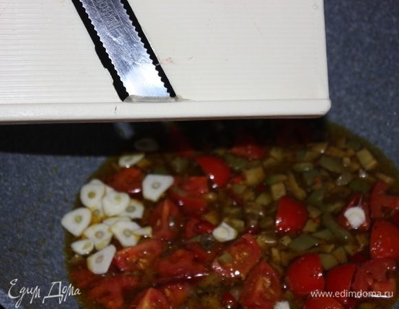 Добавить 1 зубчик чеснока, нарезанного тонкими пластиками. Как только масло начнет пузыриться, незамедлительно выкладывайте спагетти из кипящей воды в глубокую сковороду. Сильно не сцеживайте воду, пусть немного воды попадет в сковороду. Так ароматное масло хорошо прикрепится к спагетти.