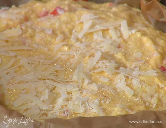 Небольшую форму выстелить бумагой для выпечки, выложить тесто, разровнять его и присыпать оставшимся сыром.