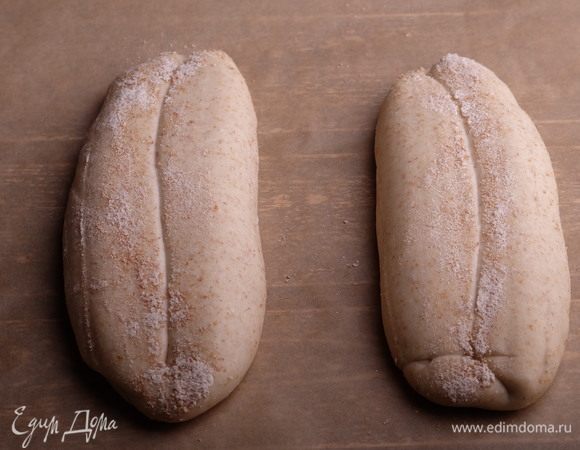 Заранее раскалить духовку с камнем для выпечки до температуры 235–250°С. Если пар будет создаваться кипятком, то духовка должна разогреваться вместе с емкостью для пара (у меня это чугунная сковорода). Если колпаком — соответственно, с колпаком. Начать разогревать духовку минимум за 1,5 часа до выпечки хлеба (в зависимости от конкретных духовок это время может меняться). Перенести хлеб на бумагу для выпечки.