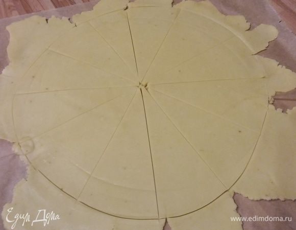 Тесто раскатать прямо на пергаменте в круг размером примерно 35 см. Отрезать неровности (из них получится еще 4 шт.). Разрезать на 12 частей. 