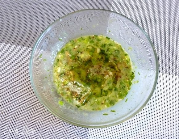 Приготовим заправку для салата. Зеленый лук мелко нарежем. Соединим в миске лук, пару ложек рассола от огурцов, лимонный сок, горчицу и душистое подсолнечное масло. Пробить немного блендером. Поперчим.