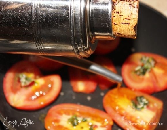 Тем временем разрезать помидоры пополам, вырезать серединки, выложить на раскаленную сковороду. На каждую половину томатов выложить порубленную смесь петрушки, соли, пеперончино (без масла). Накрыть крышкой, оставить томиться на 4–5 минут на большом огне. После этого добавить оливковое масло Extra Virgin и накрыть снова крышкой, убавив огонь до среднего. Томаты можно даже не проверять, а снять их с огня, когда все остальное будет готово.