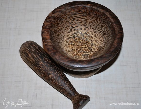 В ступке размельчим зерна кориандра. 