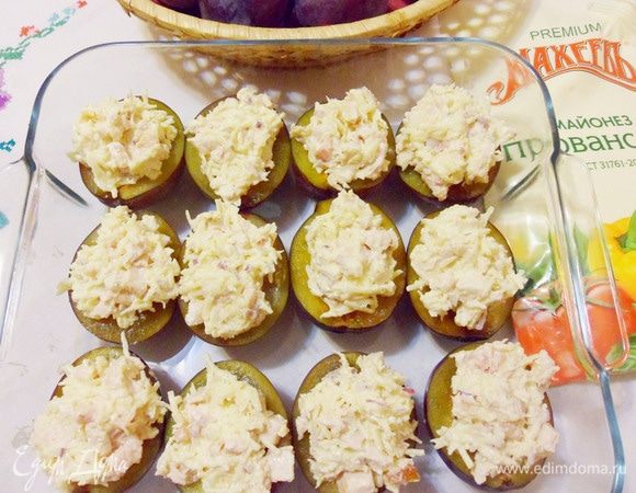 Нафаршировать половинки слив подготовленной начинкой. Запекать в предварительно разогретой до 180°С духовке около 20 минут.