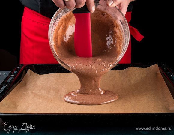 Подготовьте противень размером 30 на 40 см. Застелите пергаментом и вылейте в противень тесто ровным слоем. Выпекайте в предварительно разогретой до 180°С духовке в течение 15 минут. Когда корж будет пружинить при нажатии, он готов. Проведите лезвием ножа по периметру противня, убедитесь, что корж сможет свободно выйти. Накройте противень листом пергамента, плотно прижмите края и резко переверните противень на стол. Корж должен оказаться на пергаменте.