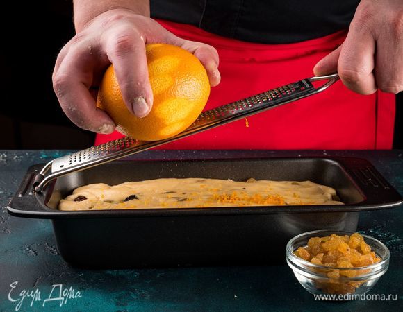 Смажьте форму растительным маслом, выложите в нее тесто, накройте его пищевой пленкой и поставьте в теплое место на 1,5 часа. С апельсина мелкой теркой снимите цедру. В готовое тесто добавьте цедру  и сухой изюм. Перемешайте, чтобы все распределилось равномерно.