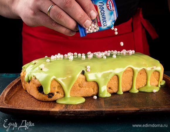 Сразу же, пока глазурь не застыла, украсьте праздничный кекс цветной посыпкой «Жемчужинки» Dr. Oetker.