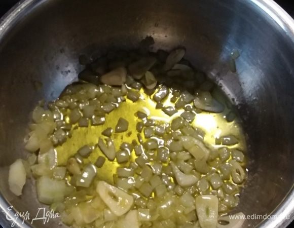 Небольшое количество масла из общего количества разогреть в сотейнике, пассеровать нарезанный кубиком лук и тонкими пластинками чеснок до прозрачности. 