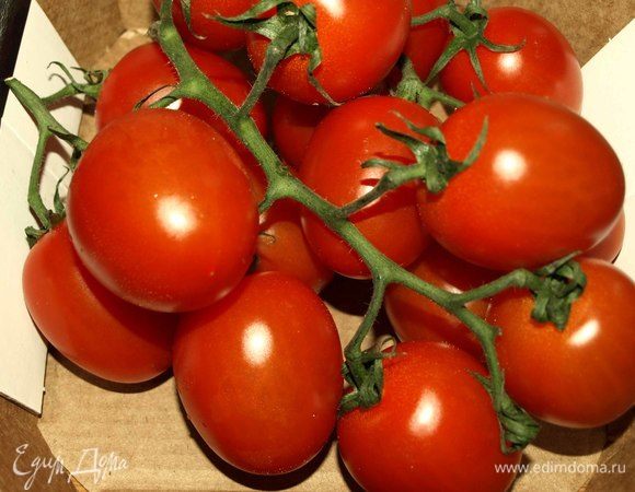 Томаты вымыть, разрезать на две половинки и отправить к картофелю.