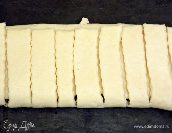 Затем накрыть полоски. Положить на противень, перевернув полосками вверх. 