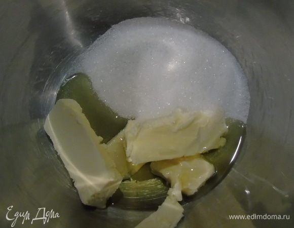 В чашу миксера всыпаем сахар, добавляем мягкое сливочное масло и оливковое масло и все взбиваем до бела.