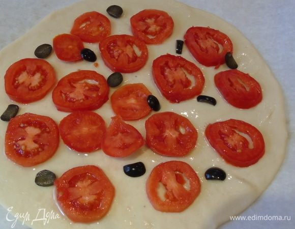 Тесто делим на три части, каждую растягиваем. Смазываем тесто оливковым маслом, выкладываем оливки и помидоры.