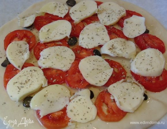 Затем моцареллу, присыпаем орегано и сбрызгиваем оливковым маслом.