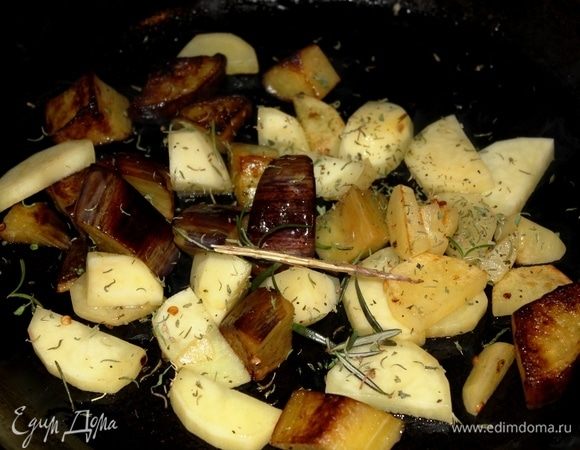 Одновременно на отдельной разогретой с оливковым маслом сковороде обжарить сначала нарезанный крупными кусочками баклажан, следом добавить картофель, чеснок крупно порубленный, тимьян, розмарин, соль по вкусу. Накрыть крышкой, и готовить на среднем огне, периодически перемешивая.