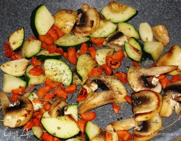 Всыпать кабачок и шампиньон в сковороду к моркови. Посолить, добавить щепотку сушеного тимьяна. Обжарить до полуготовности.
