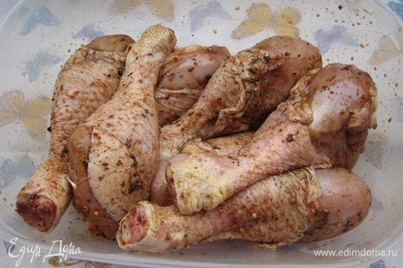 Замариновать курицу: положить голени в глубокую чашу, влить оливковое масло, соевый соус, посыпать специями, добавить зубчик чеснока, накрыть крышкой, оставить мариноваться на полчаса.