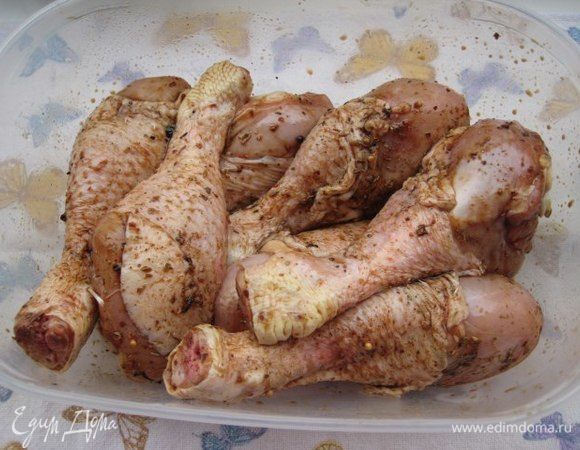 Замариновать курицу: положить голени в глубокую чашу, влить оливковое масло, соевый соус, посыпать специями, добавить зубчик чеснока, накрыть крышкой, оставить мариноваться на полчаса.