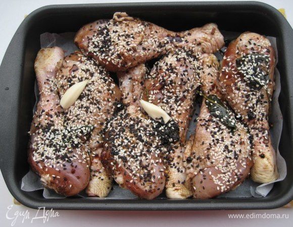 Переложить куриные голени вместе с маринадом в форму для запекания, посыпать кунжутом. Запекать при температуре 180°С до румяного цвета и готовности мяса (около 45 минут).