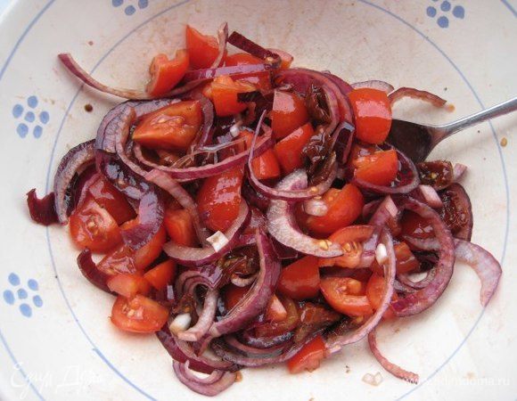 Смешать лук с помидорами, заправить хорошим оливковым маслом, бальзамическим уксусом, посыпать орегано, посолить, поперчить, убрать в холодильник на полчаса.