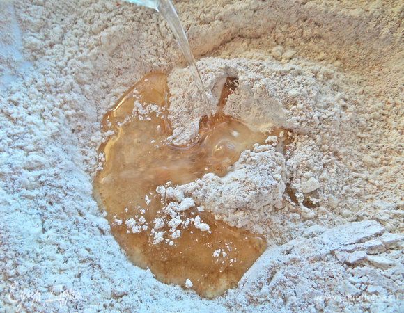 Влить масло в горячую воду и перелить в муку.