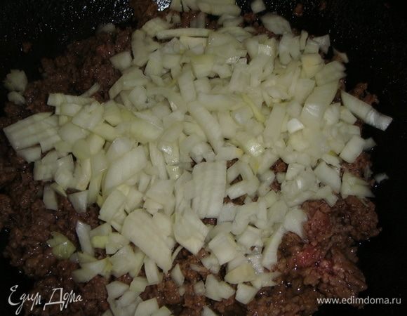 Сковороду с маслом нагреть, выложить фарш. Обжарить его 10 минут, посолить и поперчить по вкусу. Всыпать мелко нарезанный лук и обжарить до готовности.