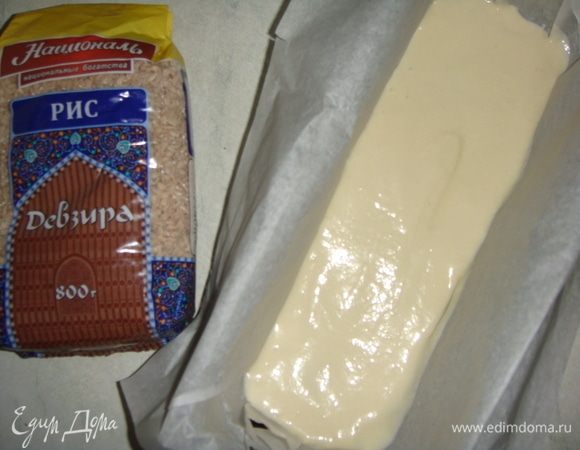 Форму для запекания застелить пергаментом, выложить чуть меньше половины теста, разровнять его ложкой.