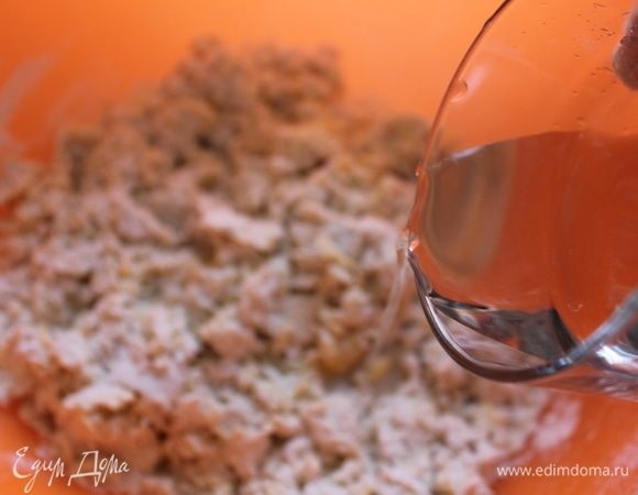 Добавить воду и начать замешивать тесто до однородной массы.