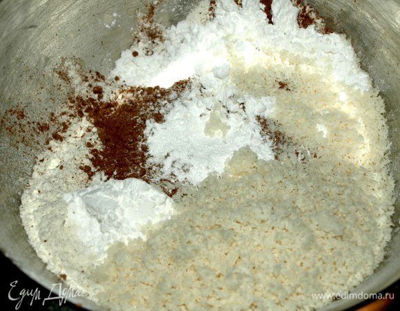 Духовку разогреть до 180°С. Муку просеять. Добавить сахарную пудру, разрыхлитель, какао ( 2 ст. ложки с горкой), соль, кокосовую стружку. Кокосовую стружку предварительно измельчить в кофемолке или блендере (до состояния муки она не измельчится, но станет воздушной). Все перемешать.