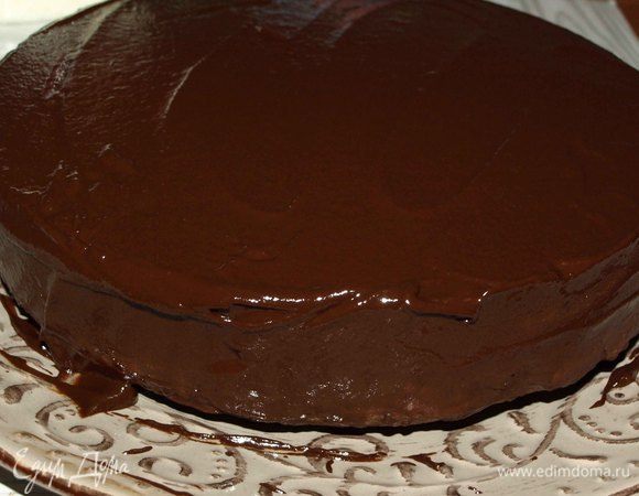 Достать готовый пирог из духовки. Оставить в форме и дать ему немного остыть. Остывший пирог перекладываем (переворачиваем) на блюдо. Готовим шоколадную глазурь: 100 г шоколада растопить на водяной бане, добавить кокосовое молоко и хорошо перемешать.