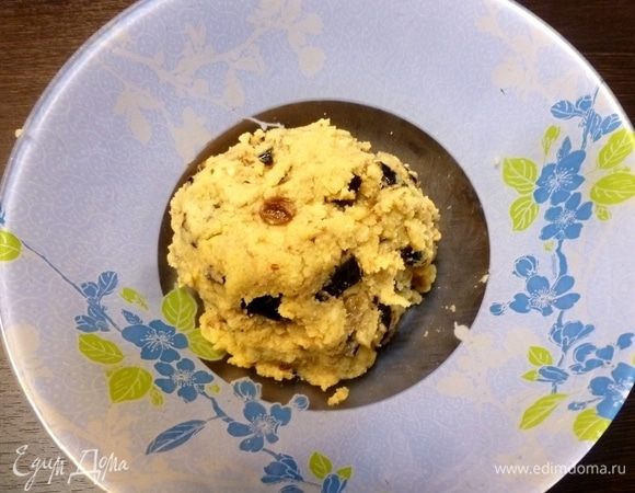 Чернослив и изюм, если твердые стоит замочить в горячей воде на 10 минут, а затем обсушить. Если изюм мелкий, как у меня, то его можно не измельчать. А вот чернослив нужно нарезать небольшими кусочками. Орехи подсушить в микроволновке или на сухой сковороде, и измельчить в блендере. Не в муку!!! Приготовим тесто. Просеем кукурузную  муку, вольем в нее оливковое масло и размешаем ложкой. Всыпем чернослив, изюм, ореховую крошку, сахар, посолим и добавим свежемолотого черного перца. Размешаем и вольем горячую (почти кипяток) воду. Хорошо размешаем. Тесто будет рыхлое, рассыпчатое, но в комок собираться должно.