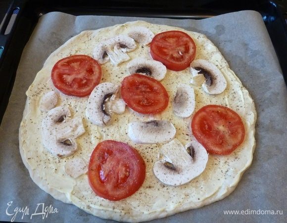 Смазываем лепешку немного майонезом. Сверху раскладываем пластинки шампиньонов, колечки помидора. Поперчим.