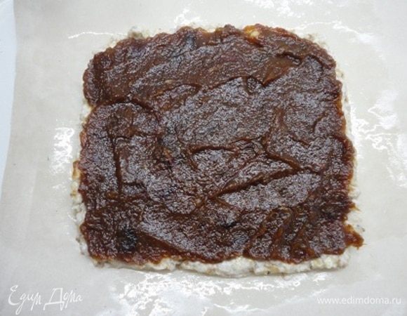 На пергамент тонким слоем выложить половину теста в форме прямоугольника примерно 15 на 15 см. Но можно и в круглую форму диаметром 20 см. Сверху выложить финиковое пюре.