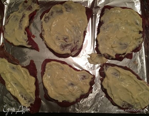 Берем противень, покрываем его фольгой. Раскладываем кусочки мяса. Сверху выкладываем чесночно-майонезный соус.