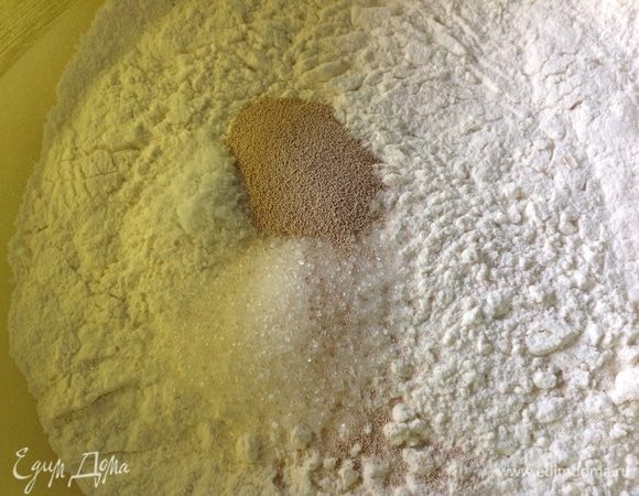 Для начала сделаю оговорку: в оригинальном рецепте идет так: соль — 0.5 ч. л., сахар — 1 ч. л., в ингредиентах я изменила соль и сахар по своим предпочтениям и вкусам, все остальное без изменений.
В миске соединяем просеянную дважды муку и пока пьете кофе пусть он подышит.
Добавляем в муку все сухие ингредиенты: сахар, соль, дрожжи и все перемешиваем венчиком.