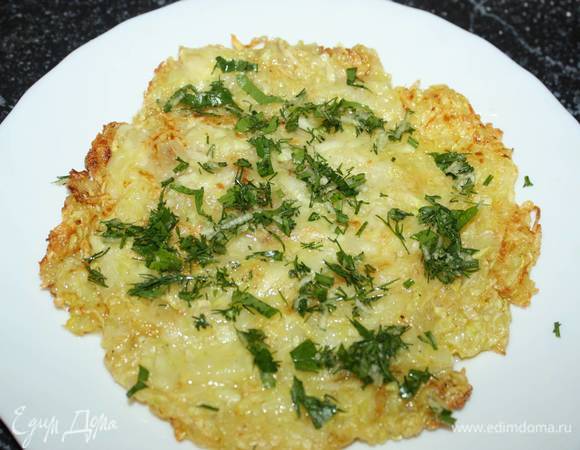 Испеченный кабачковый блин посыпаем зеленью с чесноком.  