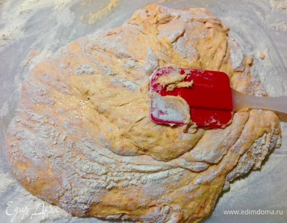 Теперь на рабочую поверхность высыпаем несколько горстей муки, выливаем на него наше тесто и с помощью силиконовой лопатки, собирая с боков муку снизу в направление верх к центру, затем переодически подсыпая уже не горстями, а щепотками муку мы замешиваем тесто до того состояния когда оно перестает липнуть к рукам.