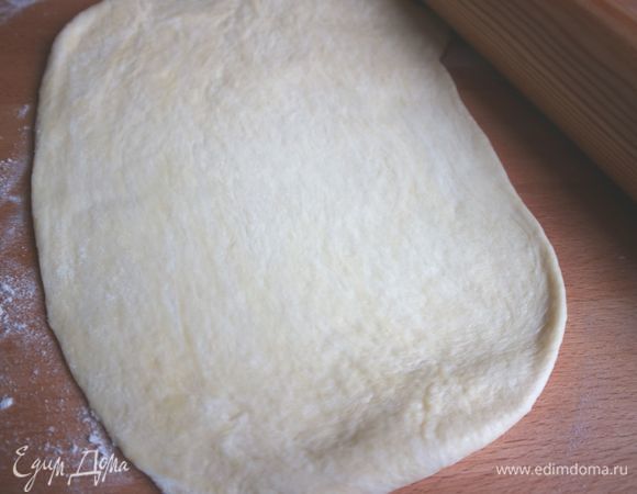 Раскатать тесто на присыпанной мукой поверхности.