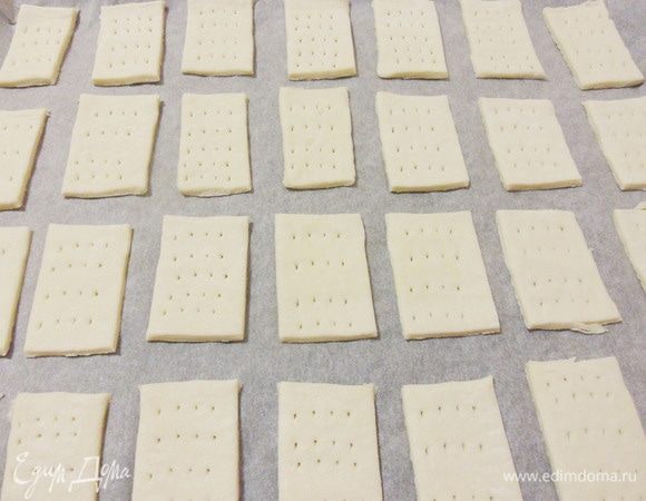 Прямоугольники теста выложить на противень и наколоть вилкой. Выпекать в предварительно разогретой до 200°С духовке до золотистого цвета.