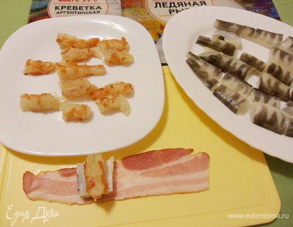 На полоску бекона положить один кусочек рыбы, на него один кусочек креветки.