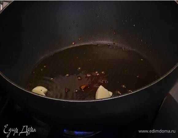 Разогреть в глубокой сковороде оливковое масло, добавить острый перец, раздавленный зубчик чеснока и все прогреть, затем чеснок удалить.