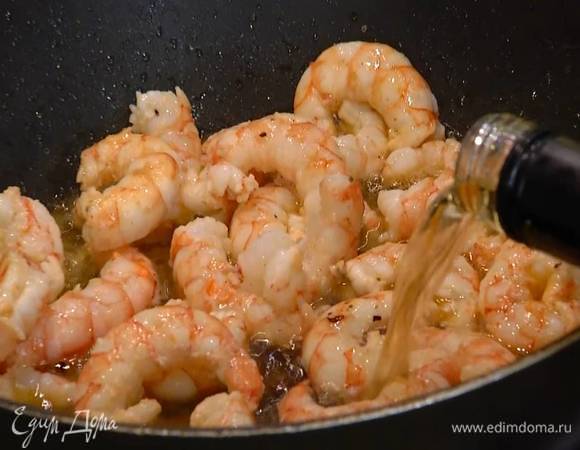 Размороженные креветки добавить в сковороду, слегка посолить и обжарить, затем влить вино, все перемешать и дать алкоголю выпариться.