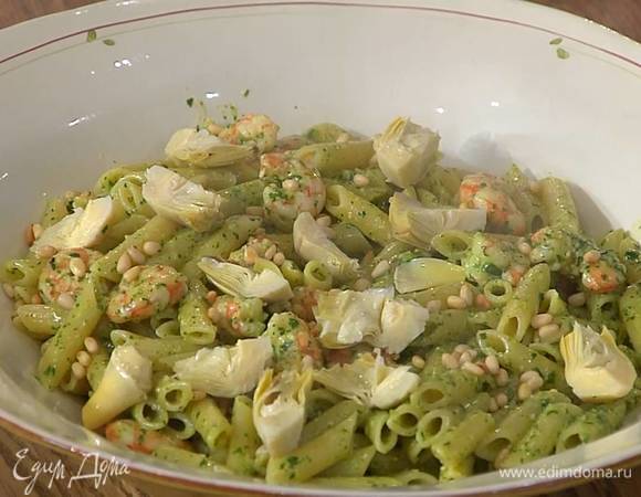 Макароны с креветками выложить в блюдо, посыпать оставшимися кедровыми орехами и украсить артишоками.