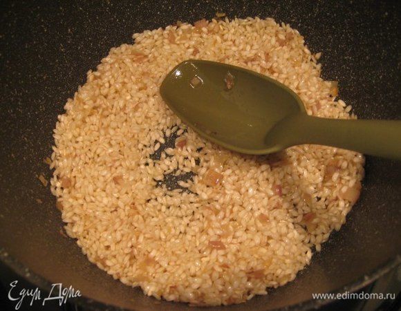 Всыпать рис, рис предварительно промывать не нужно! Помешивая готовить рис 1-2 минуты, влить вино, дать алкоголю выпариться.