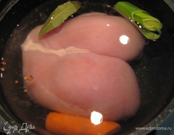 В кастрюлю положить куриную грудку, лавровый лист, морковь, кусочек лука-порея (или четвертинку репчатого лука), черный перец горошком, довести до кипения, снять пену и варить до готовности. Остудить, завернуть в пищевую пленку и убрать в холодильник на пару часов.